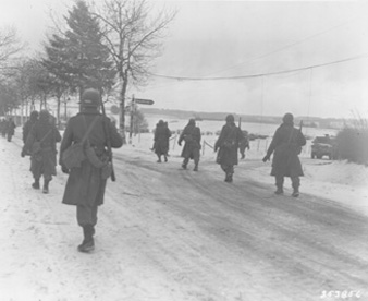 Photo:  SC253856 - The 101st Airborne troops move out of Bastogne, after having been besieged there for ten days, to drive the enemy out of the surrounding district. Belgium 12/31/45.